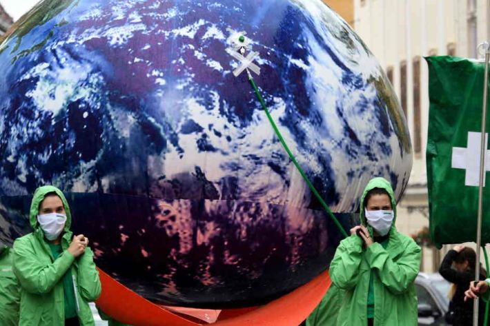 Greenpeace activists carry a giant balloon representing planet Earth