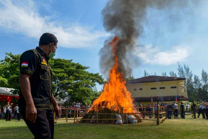  man looks at the burning of 1.8 tons of marijuana and 10 kilograms of methamphetamine in Banda Aceh, Aceh province