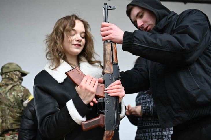 A Ukrainian women learns how to use an AK-47 rifle