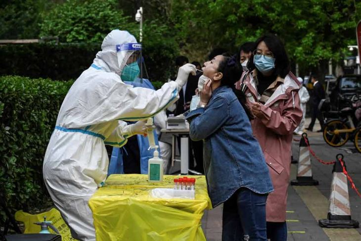 Health workers carry out swab tests in Beijing