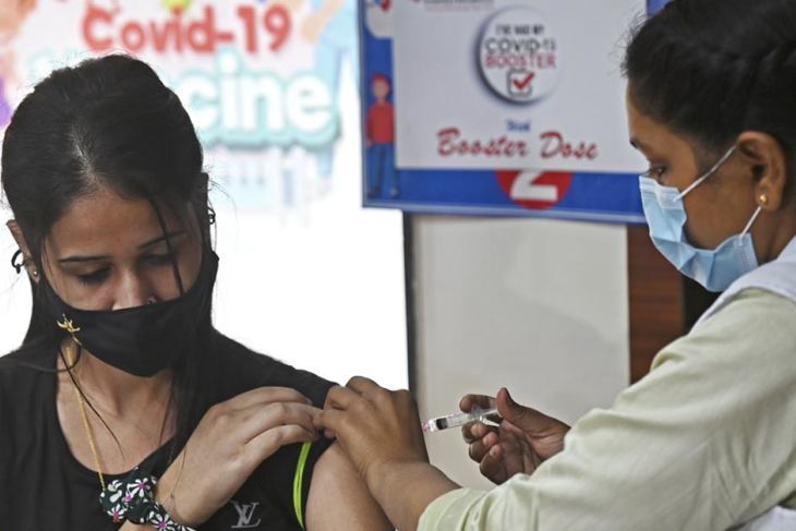 A health worker inoculates a girl with the Covaxin vaccine