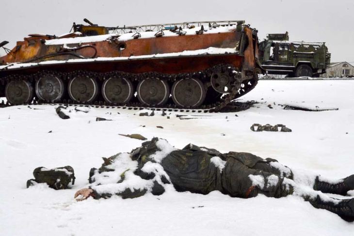 Russian soldier lies dead in front of destroyed tank 
