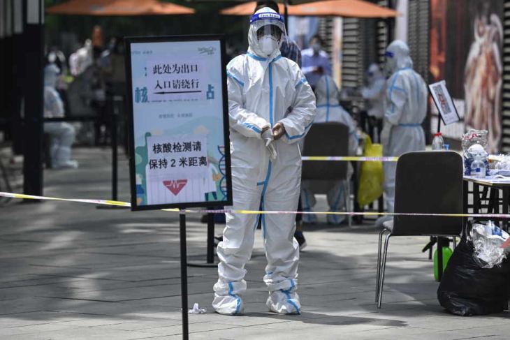 A health worker stands in front of a mall in Beijing