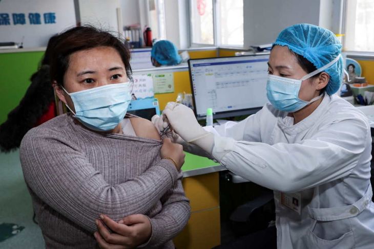 Medical worker vaccinates a woman in Jiangsu