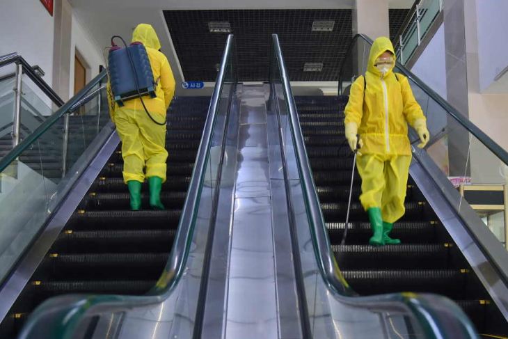 Workers disinfect a department store in Pyongyang