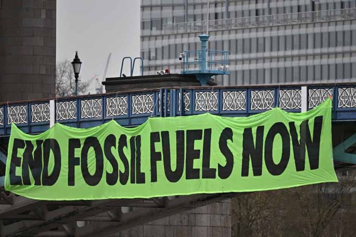 Climate activists hang a banner on Tower Bridge