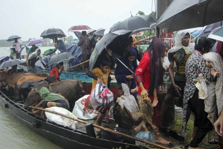 People prepare to get of a boat after being evacuated from a flooded area 
