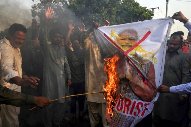 Protestors burn a picture of India's PM in Karachi