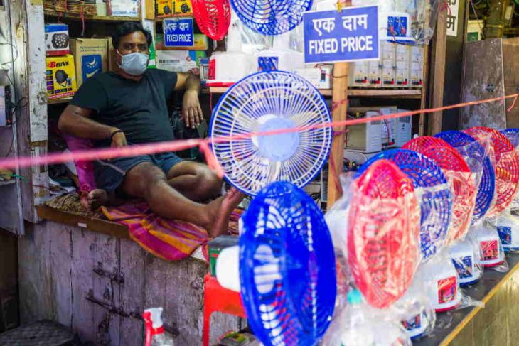 A man displaying fans at his store in New Delhi