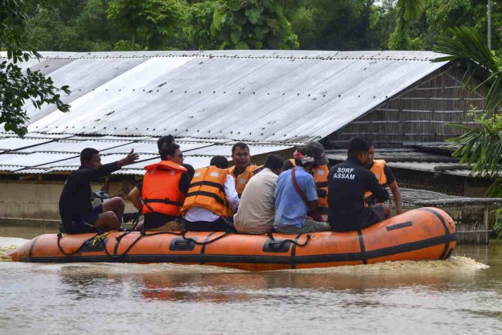 SDRF personnel make their way on a boat through flood water in Assam state